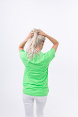 Back view of a woman in the FUN Mark Tee – Neon Green, grabbing her hair. A statement tee made to pop—front, back, all sides.