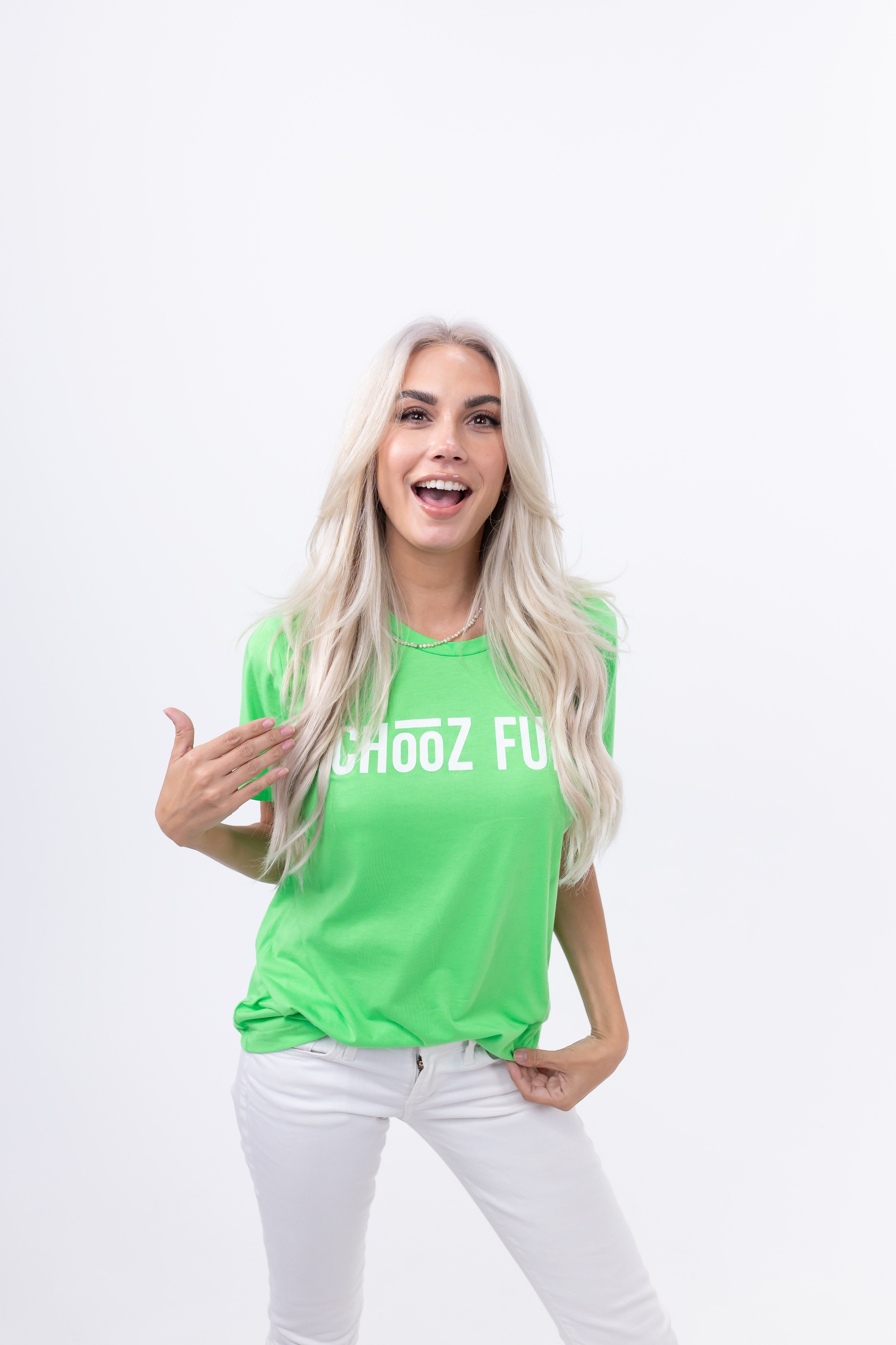 Woman in the FUN Mark Tee – Neon Green, pointing proudly to the logo. This tee doesn’t whisper—it pops.