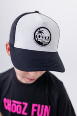 Close-up of child wearing black and white CHooZ FUN curved brim hat with palm logo – Lil’ Palm Party Tropic Thunder Youth Hat