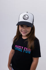 Young girl smiling in CHooZ FUN black and white trucker hat – Lil’ Palm Party Tropic Thunder Youth Hat